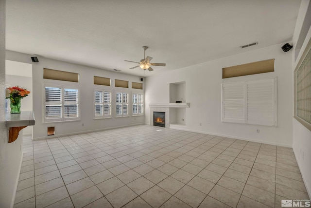 unfurnished living room with visible vents, baseboards, a tile fireplace, ceiling fan, and tile patterned floors