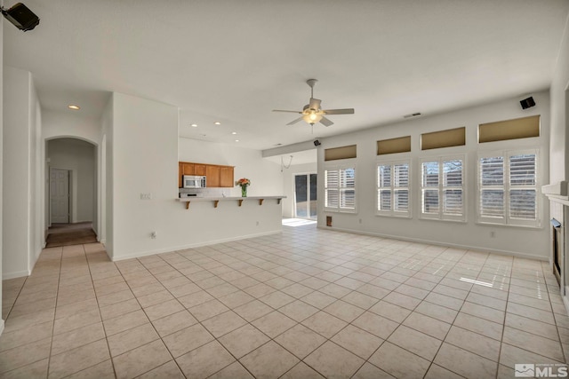 unfurnished living room featuring ceiling fan, light tile patterned floors, arched walkways, recessed lighting, and visible vents