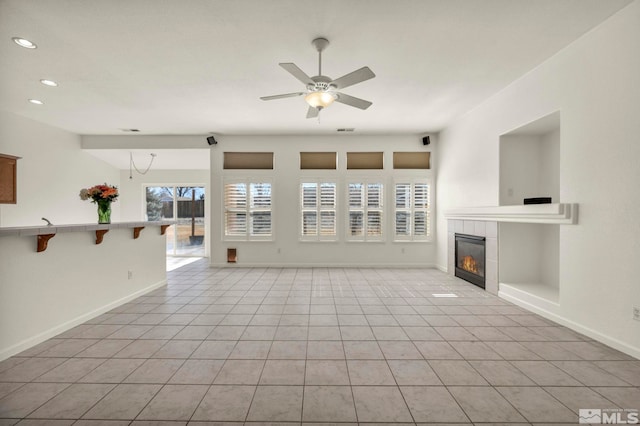 unfurnished living room with light tile patterned floors, baseboards, a ceiling fan, a fireplace, and recessed lighting