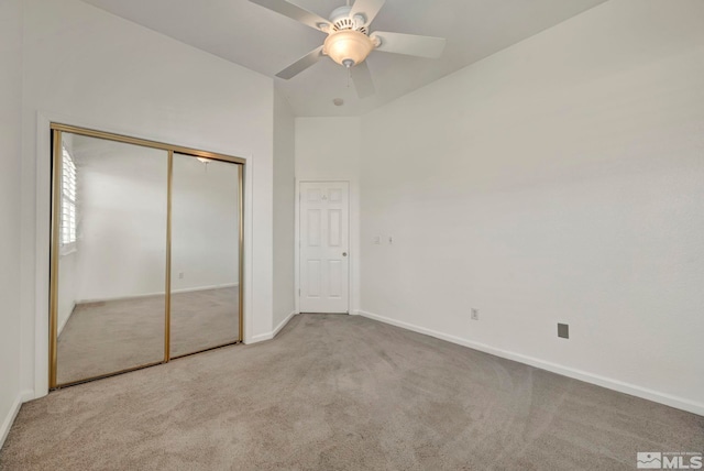 unfurnished bedroom featuring carpet, a closet, ceiling fan, and baseboards