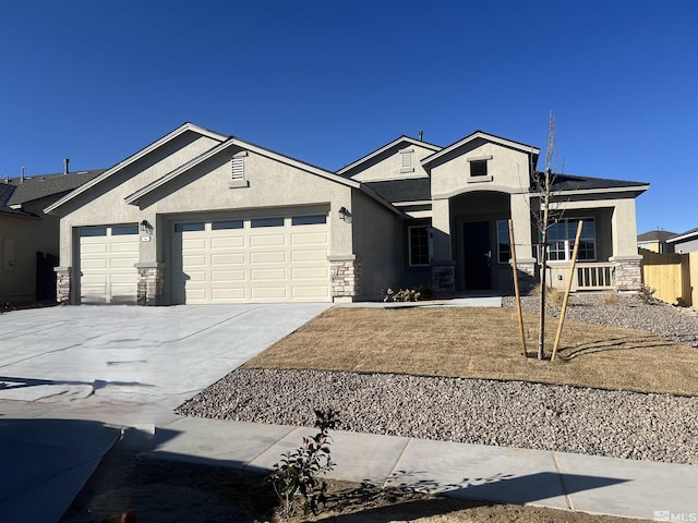 view of front of home featuring driveway, stone siding, an attached garage, fence, and stucco siding