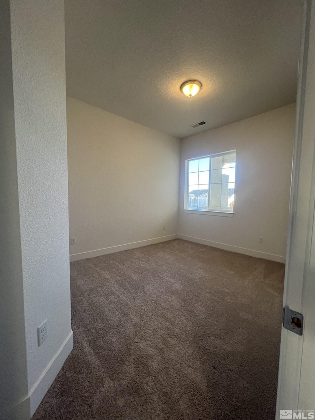 carpeted empty room with visible vents, a textured ceiling, and baseboards