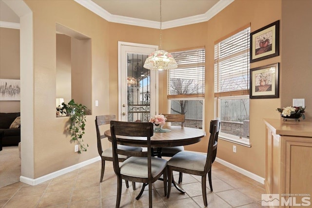 dining area featuring light tile patterned flooring, crown molding, and baseboards