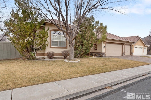 obstructed view of property with a tiled roof, a front yard, fence, and stucco siding