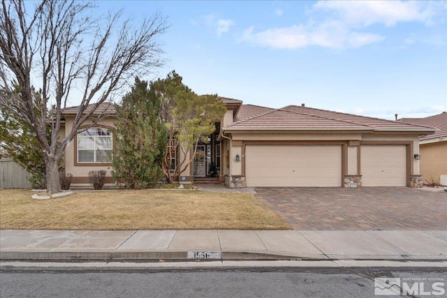 view of front of house with stone siding, an attached garage, decorative driveway, a front lawn, and stucco siding