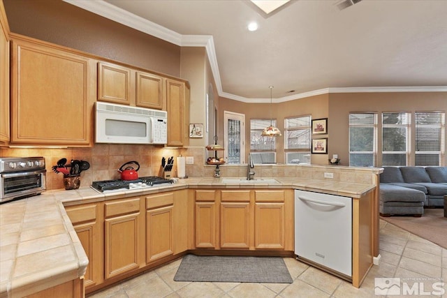 kitchen with a toaster, a peninsula, white appliances, a sink, and open floor plan