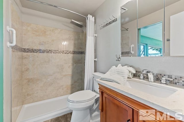 bathroom featuring vanity, tasteful backsplash, a tile shower, and toilet