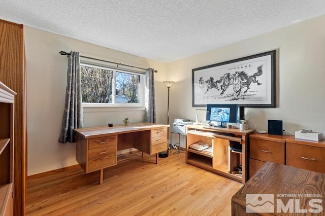 office with light wood-style floors and a textured ceiling