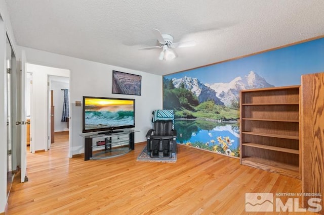 unfurnished living room with a ceiling fan, a textured ceiling, and wood finished floors