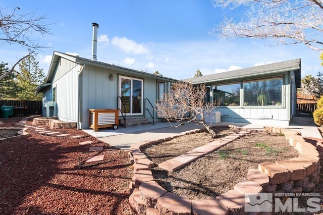 rear view of house featuring entry steps, a patio, and fence