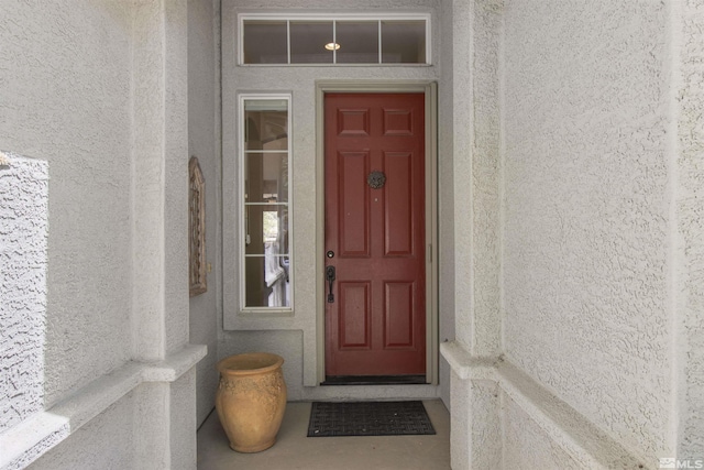 view of exterior entry featuring stucco siding