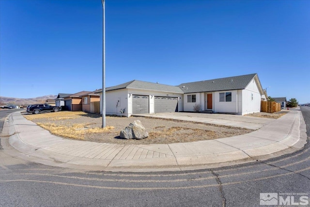 ranch-style house with a garage and fence