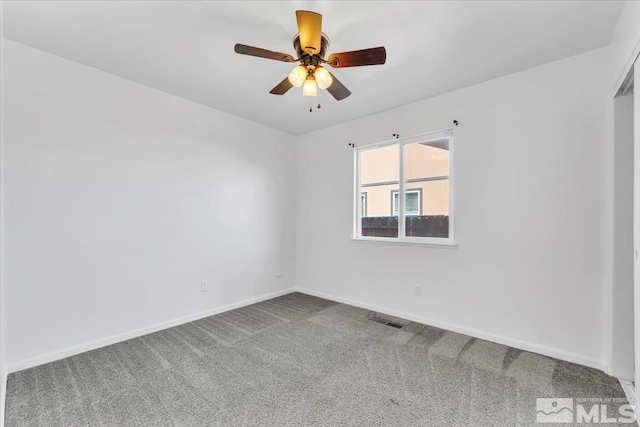 unfurnished room featuring carpet floors, a ceiling fan, visible vents, and baseboards