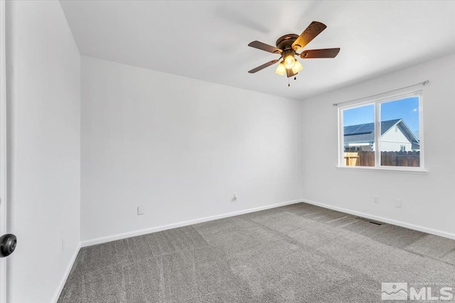 unfurnished room with carpet, visible vents, baseboards, and ceiling fan