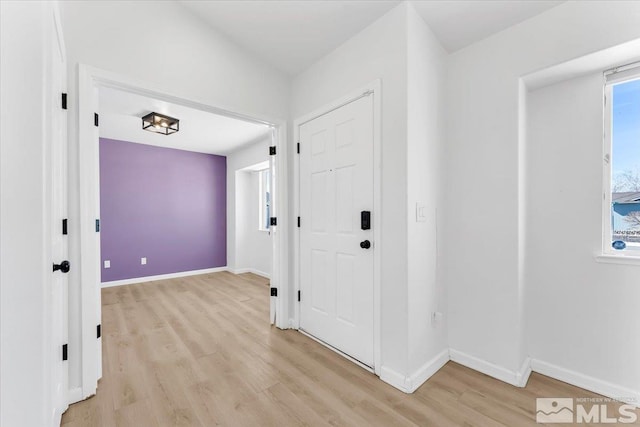 hall featuring light wood-style floors and baseboards