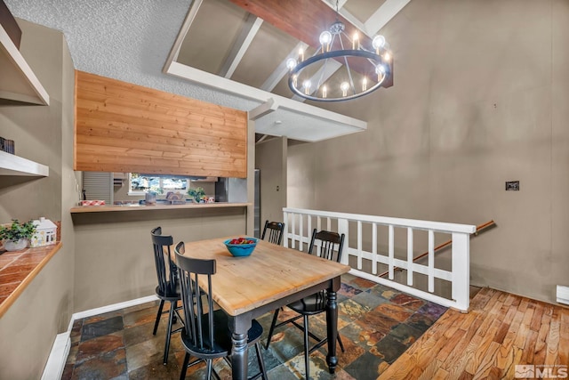 dining space featuring stone finish flooring and a chandelier