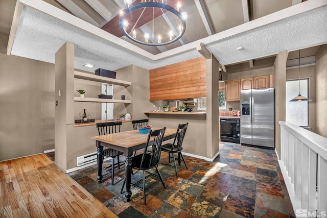 dining area with a textured ceiling, stone finish flooring, baseboards, and an inviting chandelier