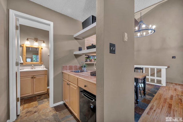 interior space with tile countertops, light brown cabinets, stone finish flooring, a sink, and open shelves