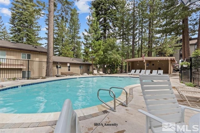 community pool featuring a patio and fence