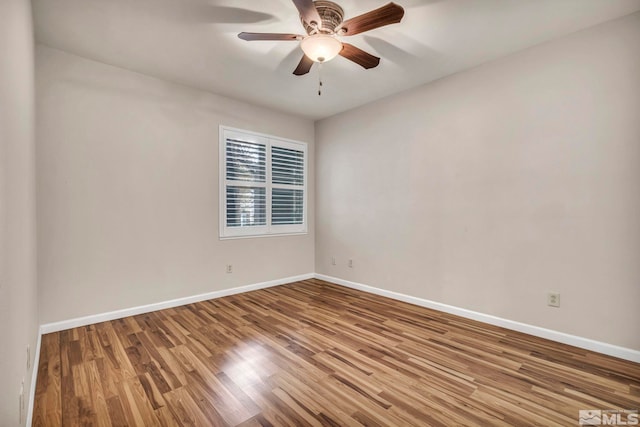 empty room featuring ceiling fan, wood finished floors, and baseboards