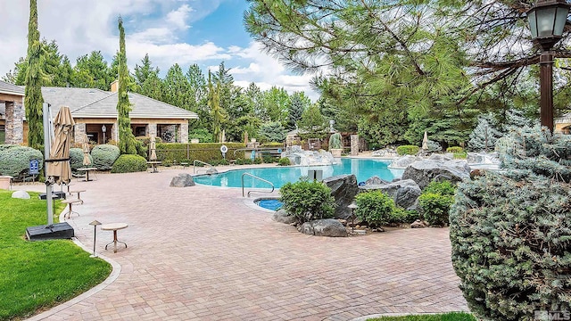 pool with a patio area and fence