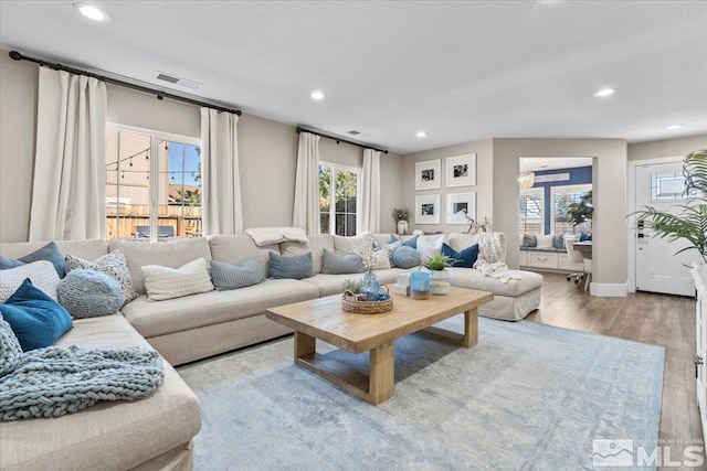 living area with visible vents, wood finished floors, and recessed lighting