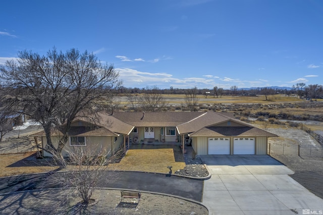 view of front of property with driveway, an attached garage, and fence