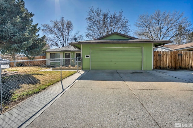 ranch-style house with driveway, a fenced front yard, and an attached garage