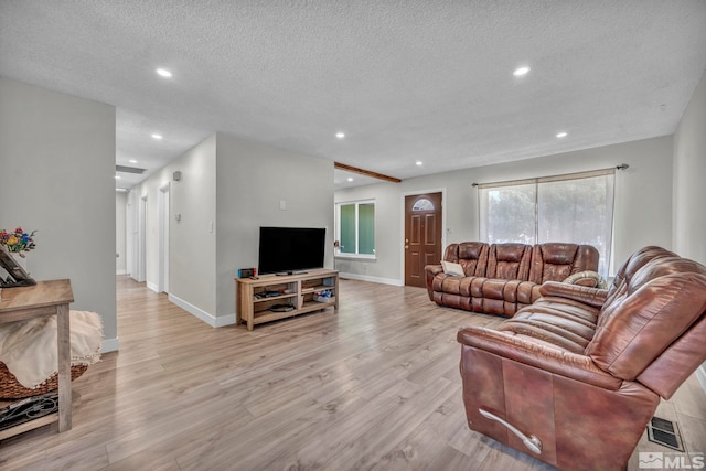 living area featuring recessed lighting, a textured ceiling, baseboards, and wood finished floors