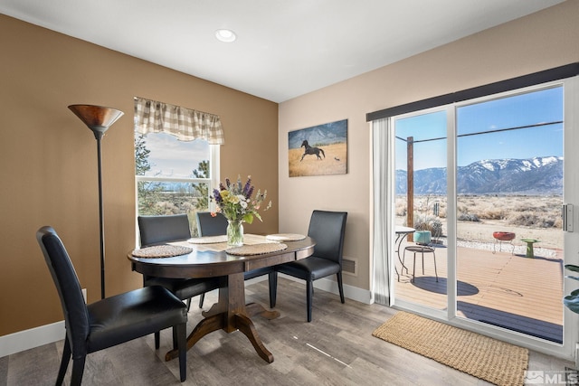 dining space featuring visible vents, a mountain view, baseboards, and wood finished floors