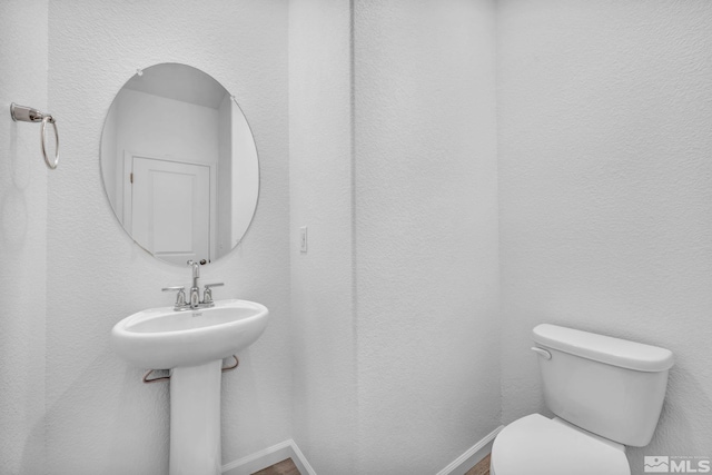 bathroom featuring toilet and baseboards