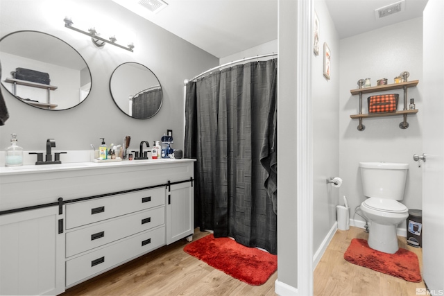 full bath featuring a sink, visible vents, toilet, and wood finished floors