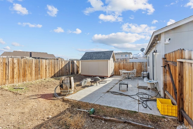 view of patio featuring an outbuilding, a storage unit, and a fenced backyard