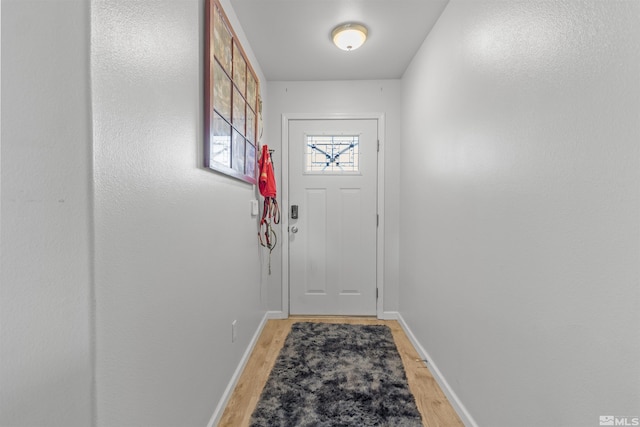 entryway with light wood-type flooring and baseboards