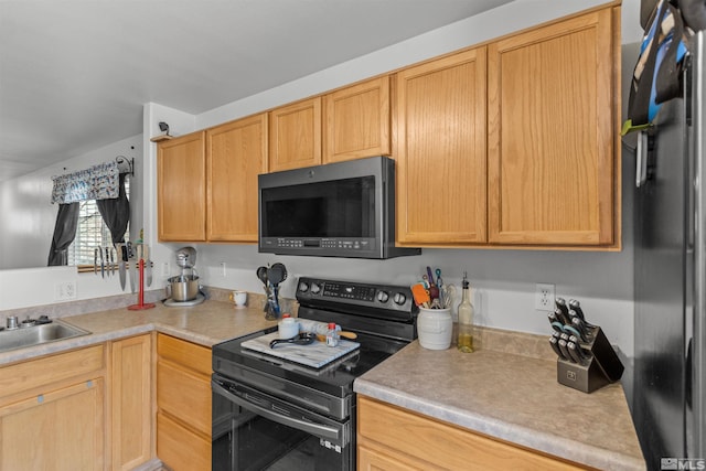 kitchen with light countertops, black range with electric cooktop, fridge, and a sink