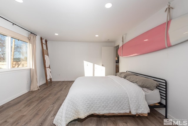 bedroom with baseboards, wood finished floors, and recessed lighting