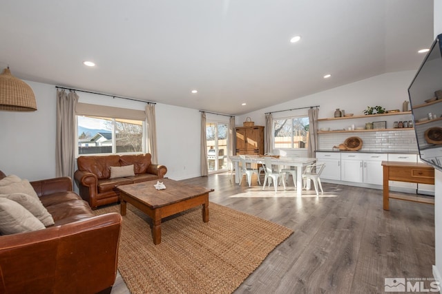 living area with recessed lighting, a healthy amount of sunlight, vaulted ceiling, and wood finished floors