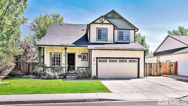 view of front of home featuring driveway, a garage, fence, and a front yard