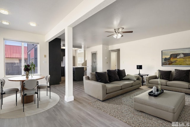 living room featuring a ceiling fan and light wood finished floors