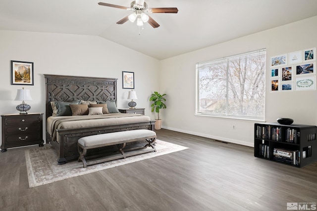 bedroom featuring ceiling fan, wood finished floors, visible vents, baseboards, and vaulted ceiling