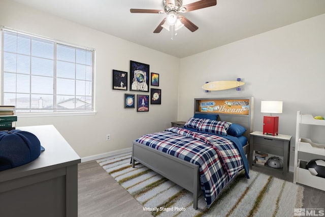 bedroom featuring wood finished floors, a ceiling fan, and baseboards