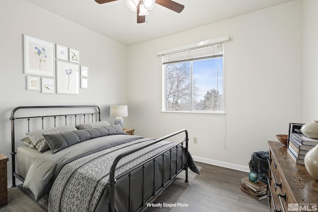 bedroom featuring a ceiling fan, baseboards, and wood finished floors