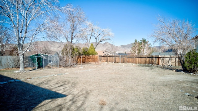 view of yard featuring a fenced backyard and a mountain view