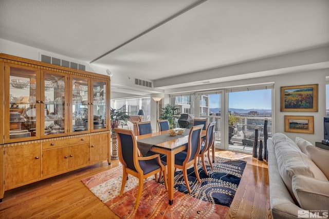 dining room with light wood-style floors and visible vents