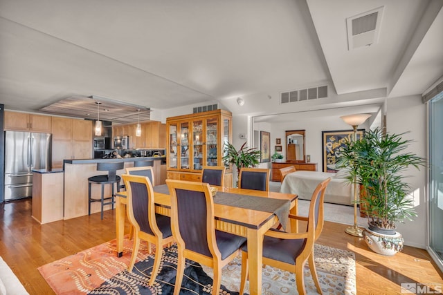 dining area with visible vents and wood finished floors
