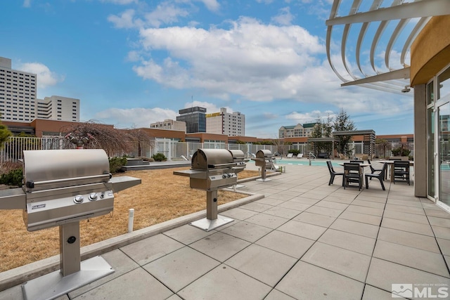 view of patio with a community pool, fence, grilling area, and a pergola