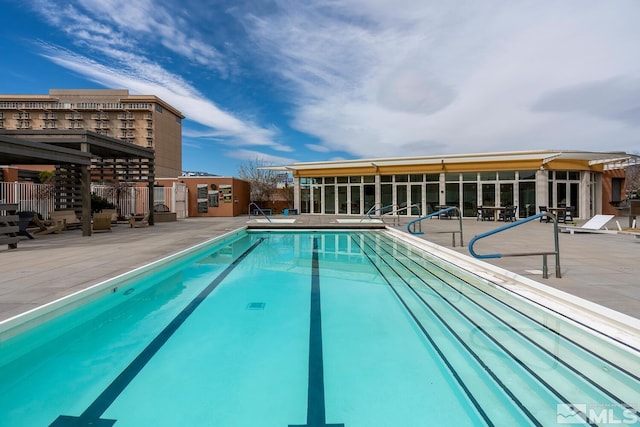 community pool featuring a sunroom and a patio