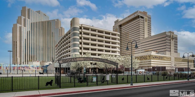 view of building exterior with fence and a city view