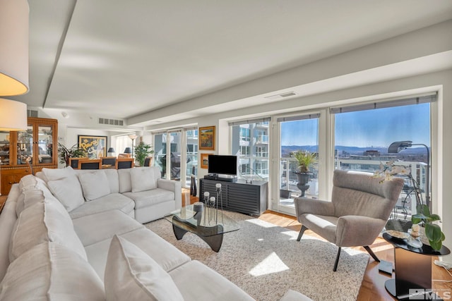 living area with visible vents and wood finished floors