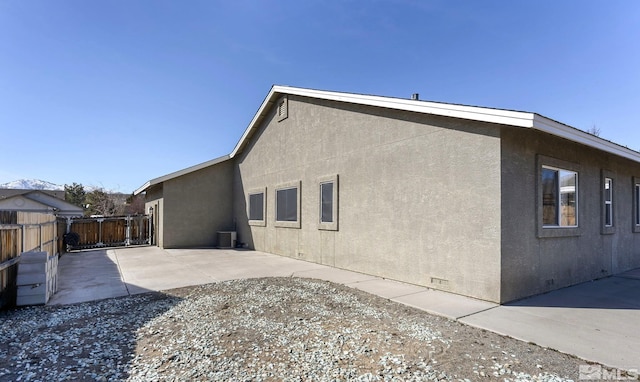 rear view of house with a patio, stucco siding, central air condition unit, crawl space, and fence